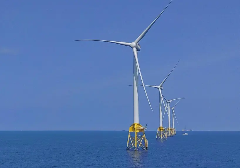 Wind turbine in the ocean with yellow base