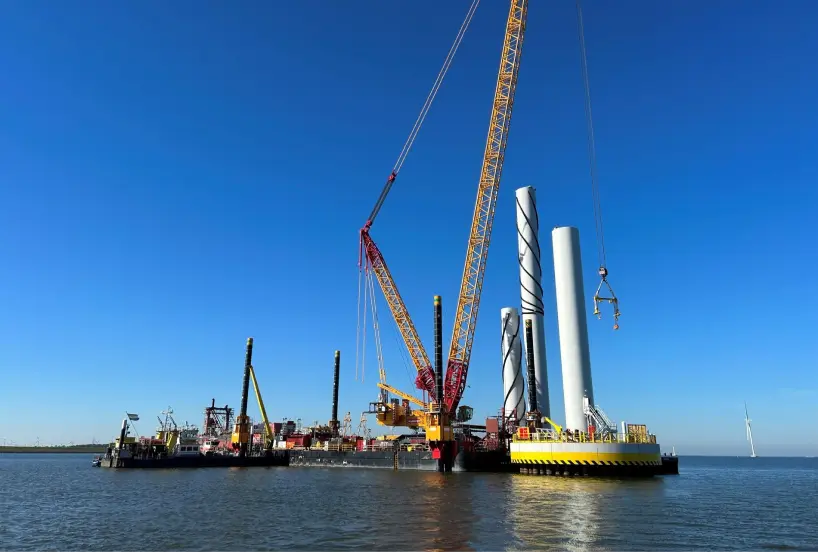 Image of wind park being built with blue sky on the ocean